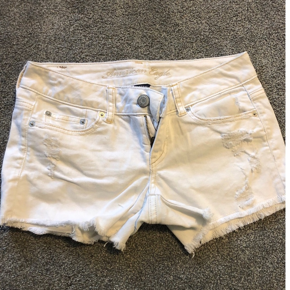 White denim shorts with ripped details.